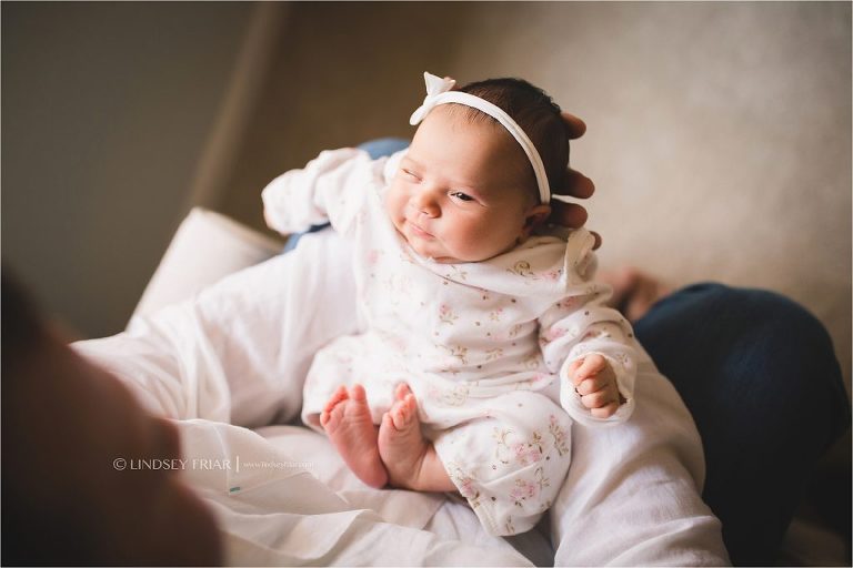 newborn girl taking a little peek at  her daddy