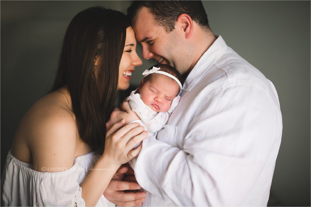 mom and dad in love over a newborn
