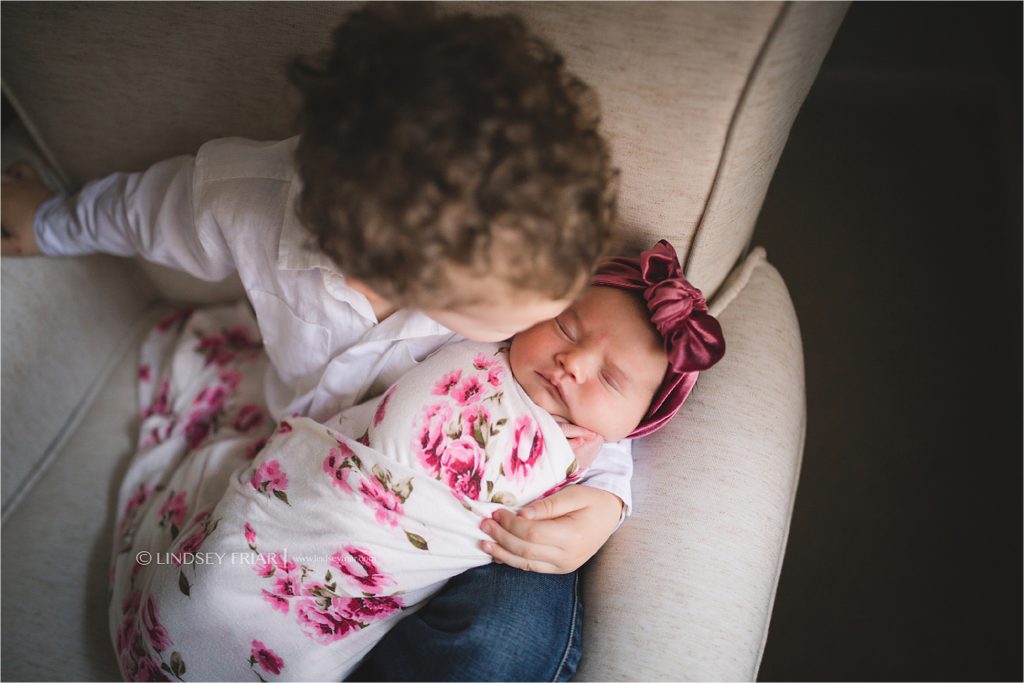 newborn sibling posing