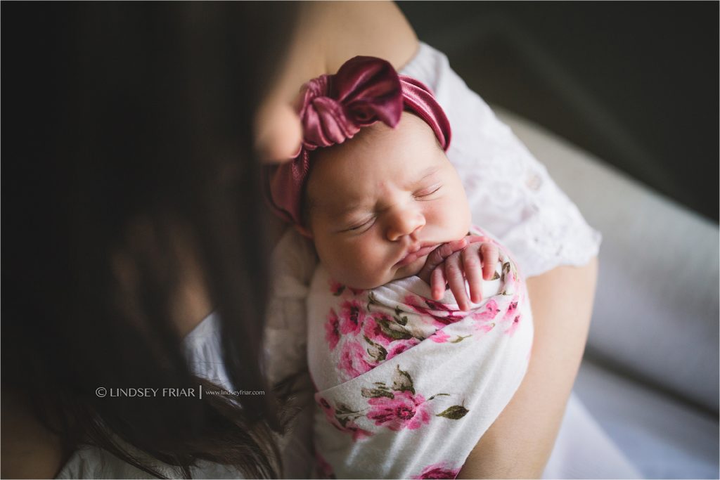 focus on newborn girl with her hands under her chin