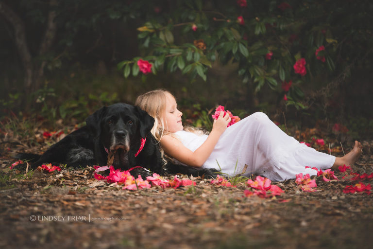 a girl lounging back on  her dog in her own world