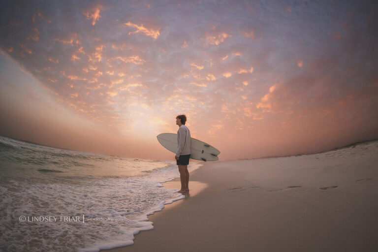 silhouette of a surfer in front of a sunset