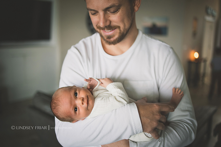 Dad holding newborn boy in his arms