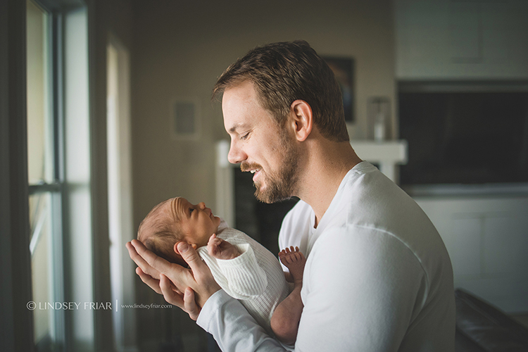 dad craddling his son's head in his hands while looking over him