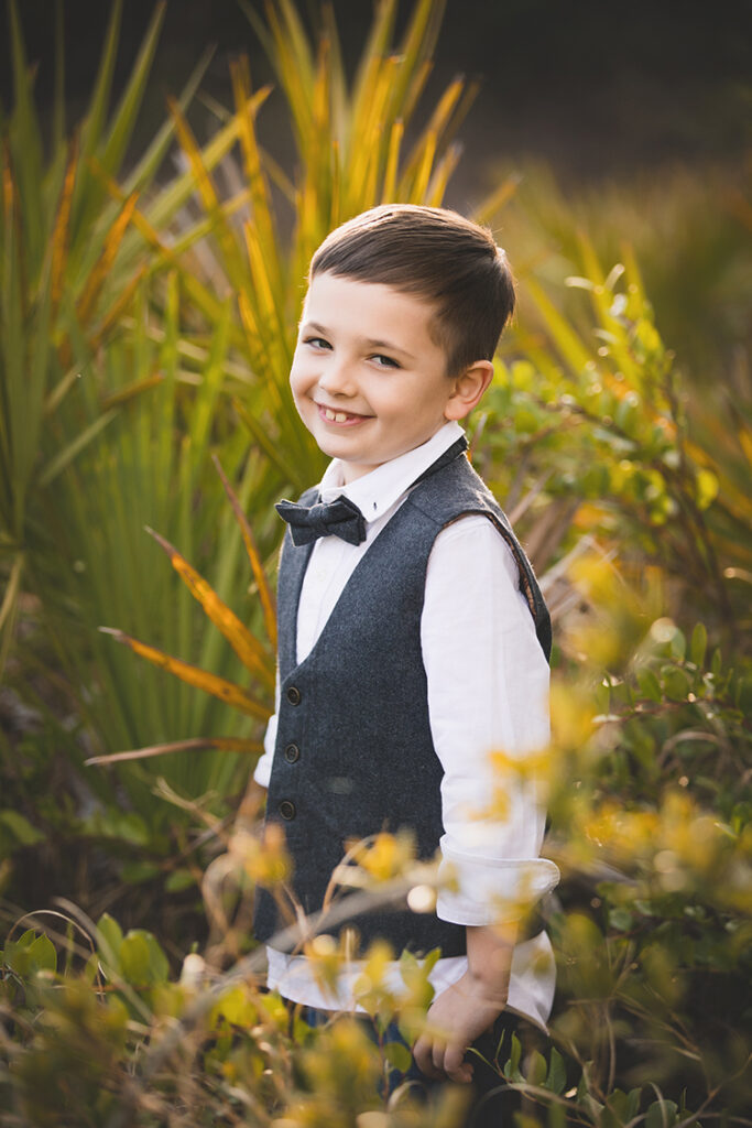 portrait of a boy wearing a vest and bow tie
