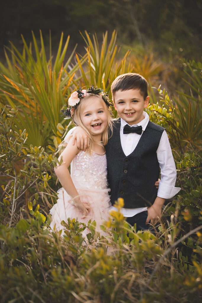 dressed up girl and boy laughing at the camera