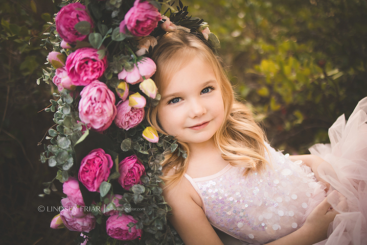 little girl laying on pink flowers