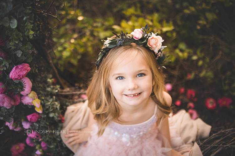 little girl with blonde hair and blue eyes looking up at the viewer