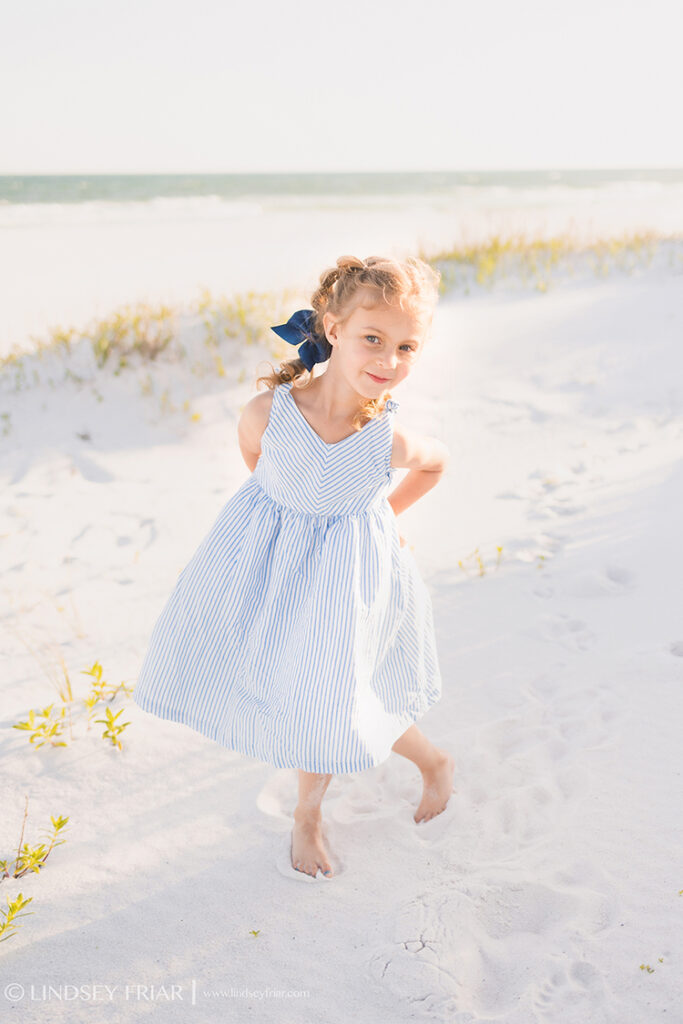 5 year old girl posing with her hands on her hips on the beach
