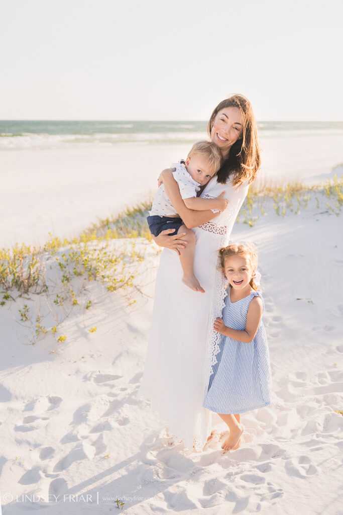 mother holding her children on the beach