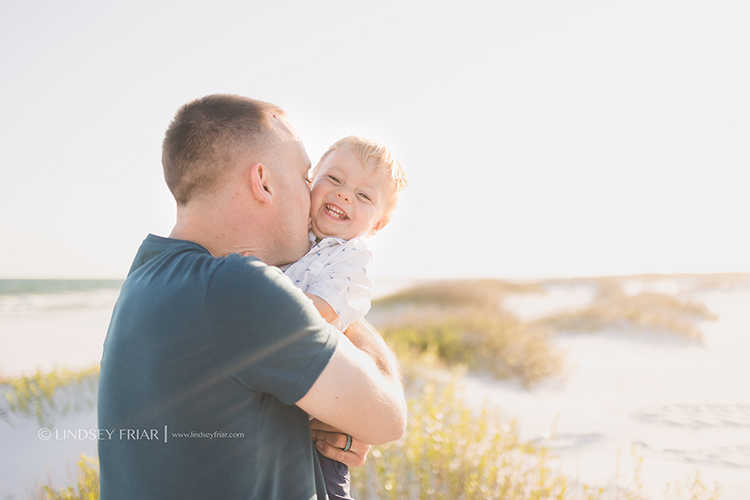 Dad kissing his toddler making him laugh