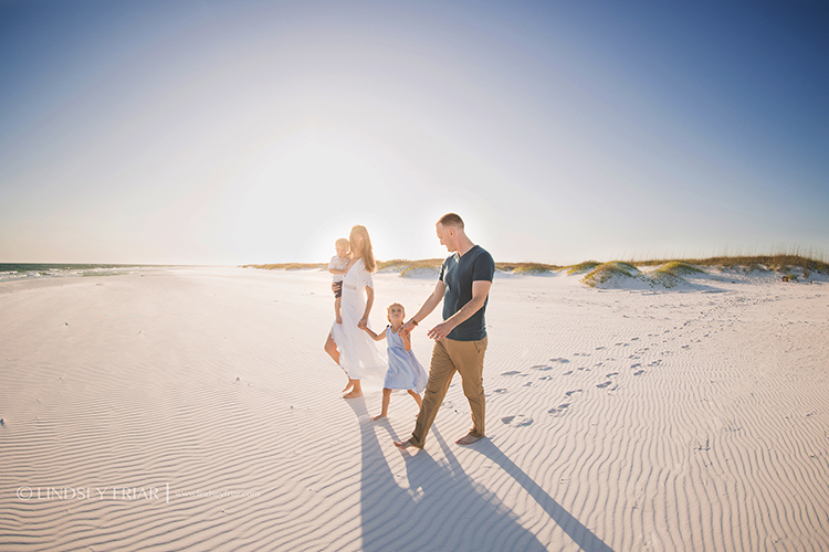 famiy walking hand in hand on beach