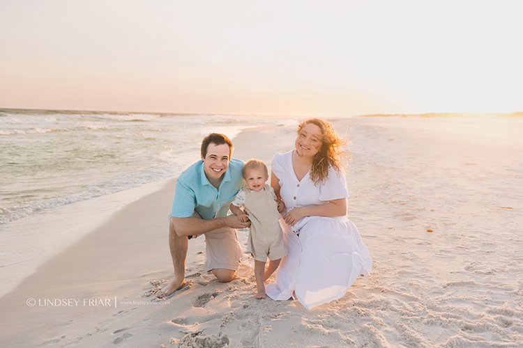 family on beach posing for a photo