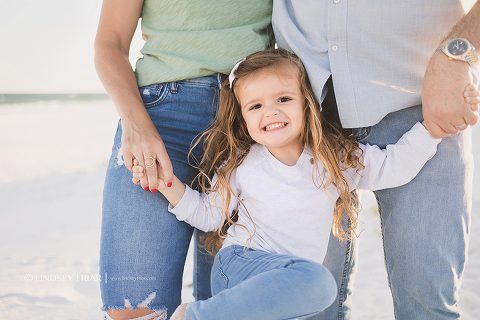 closeup shot of little girl holding her parents hands