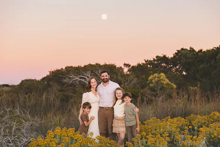 family standing in front of moon in yellow flowers